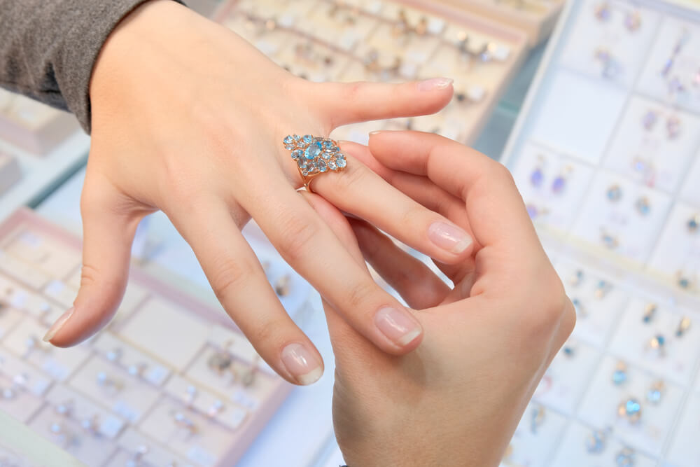 A girl trying a diamond ring on her finger